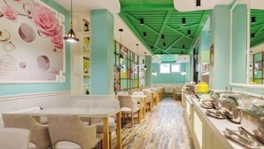 A restaurant with a long counter, seating area, and a green ceiling. - Hongji Business Hotel (Fujin)