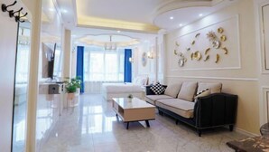 A modern living room with a sofa, coffee table, and decorative wall art. - Hongji Business Hotel (Fujin)