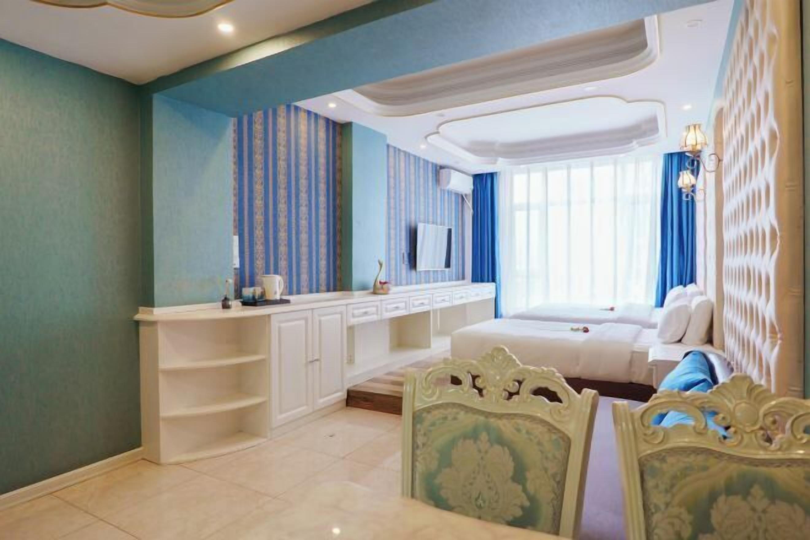 A hotel room with a bed, a TV, a desk, and a chair.