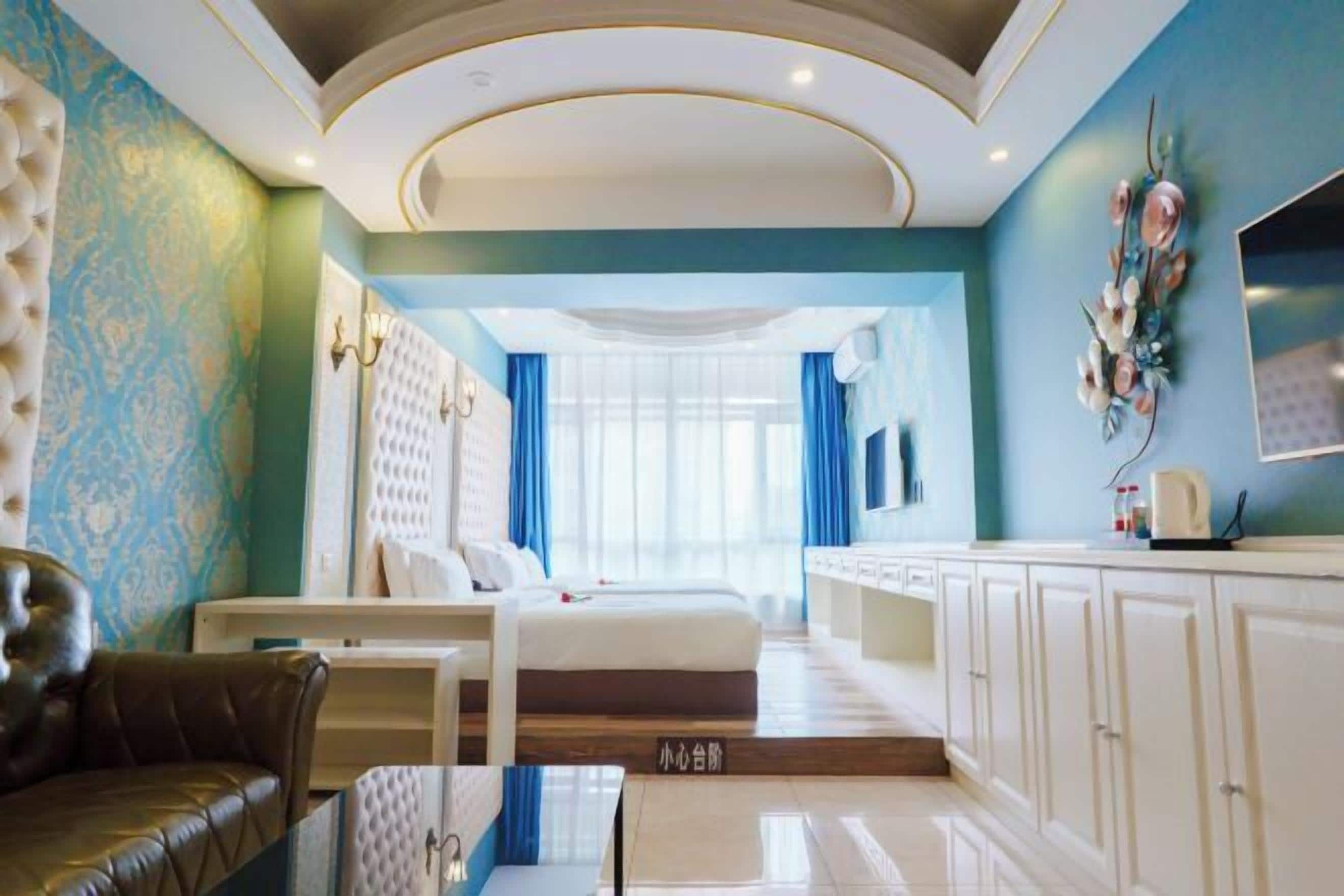 Ein Hotelzimmer mit Bett, Sofa, Esstisch und Küchenzeile.