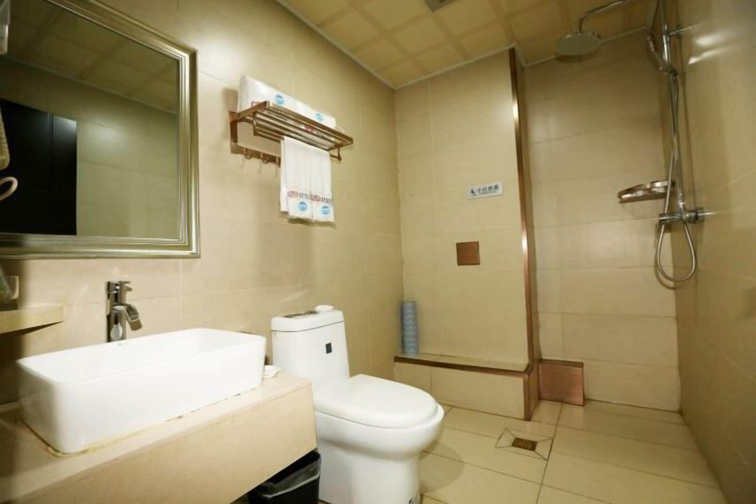 A bathroom with a sink, toilet, and shower.