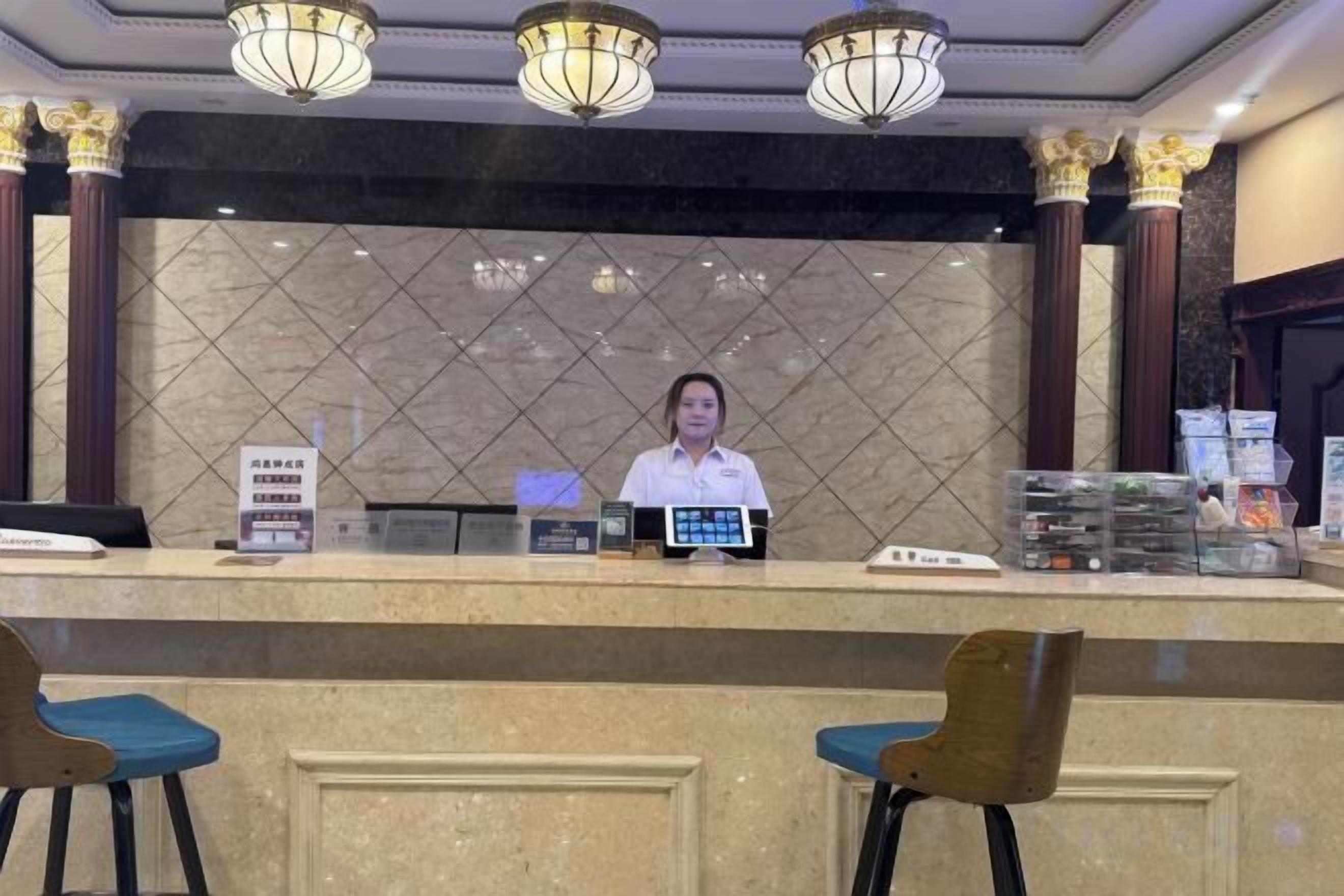 A reception desk with a digital display, a signboard, and a counter.
