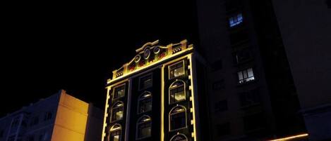 A multi-story building with illuminated signage and windows, suggesting a commercial or hotel property.