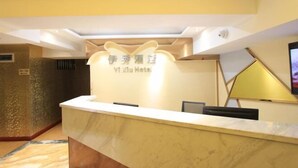 A hotel reception desk with a marble counter and a sign above it. - Yi Xiu Hotel (Chongqing)