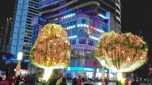 A modern building with illuminated signage and large spherical structures in front. - Yi Xiu Hotel (Chongqing)