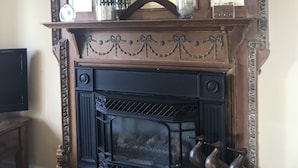 A fireplace with a decorative mantel, a mirror above it, and two bird sculptures on the mantel. - Dicksons Family Suite B&B (Niagara-on-the-Lake)