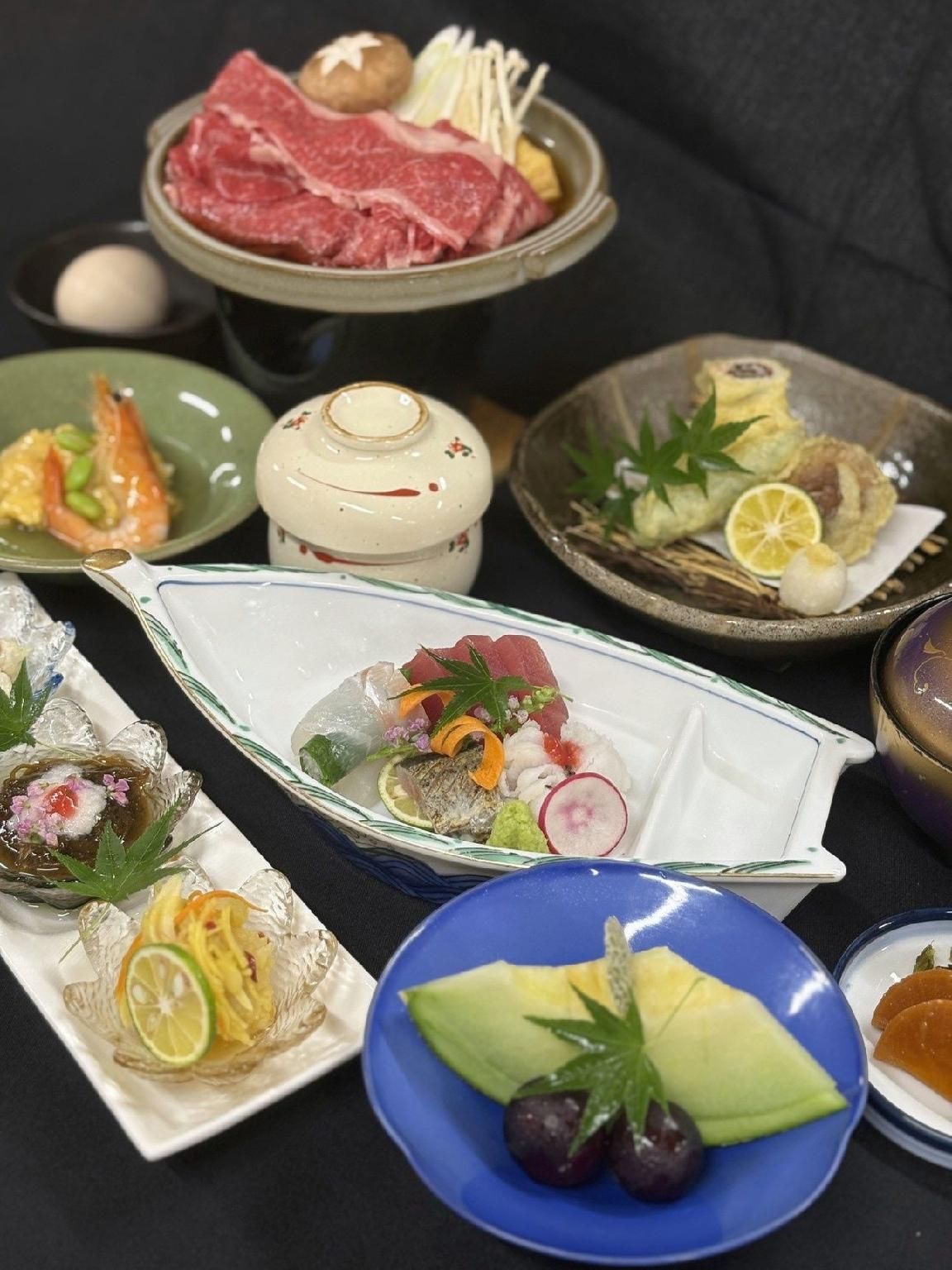 A variety of dishes on a table, including sushi, sashimi, and other Japanese cuisine.