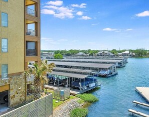 Un hotel frente al agua con varias estructuras flotantes, un edificio de piedra y una vista despejada del mar.