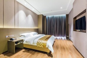 A modern hotel room with a bed, bedside table, and a TV.