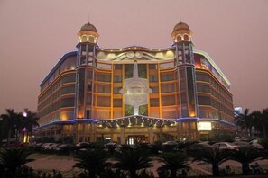 A multi-story hotel with a central atrium, multiple balconies, and a large entrance.