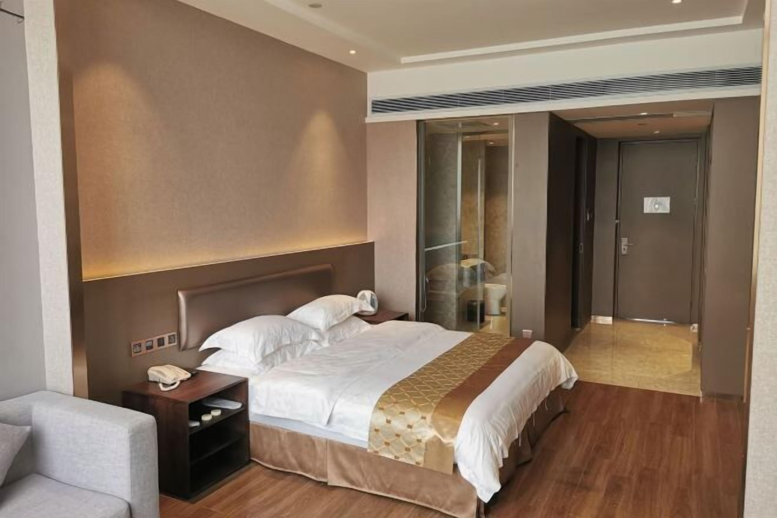 Una habitación de hotel con cama, mesita de noche y una silla.