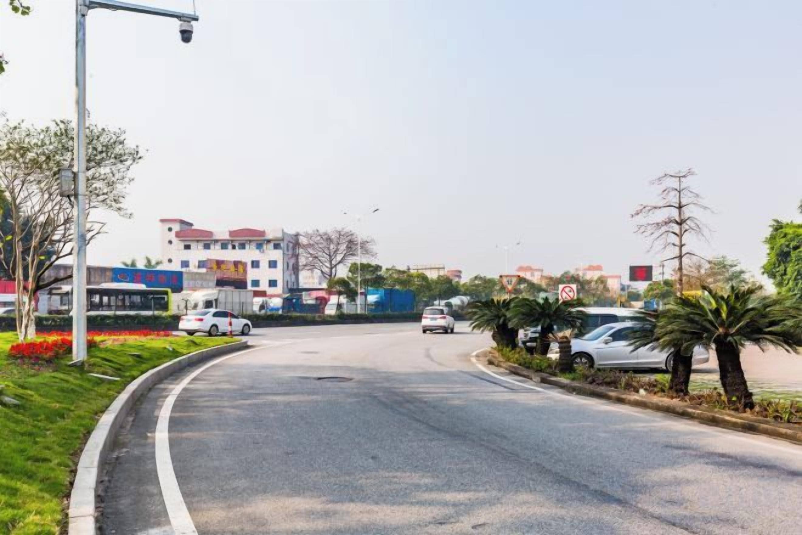 A road with cars, a pedestrian crossing, and buildings in the background.