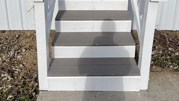 A set of white wooden stairs leading to a front door with a window above it. - Life at the Dairy Farm (New Enterprise)