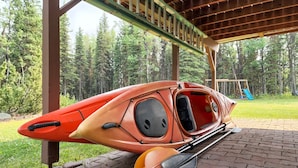 A kayak and paddle leaning against a wooden structure in a park. - Alaska Fly In / Drive In, Kenai Peninsula Lodging (Sterling)
