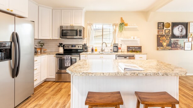 A modern kitchen with white cabinetry, stainless steel appliances, and a granite countertop. - Kid-Friendly 2 Bedroom close to Idaho Center & NNU (Nampa)
