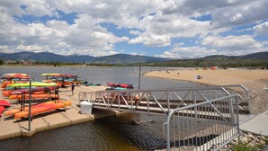 A dock with colorful kayaks and a bridge leading to a sandy beach. - Downtown Location walk to Main Street and Gondola from this updated Condo (Breckenridge)
