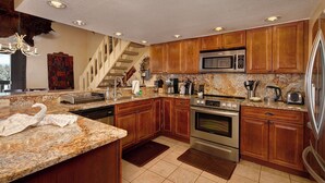 A kitchen with wooden cabinets, granite countertops, stainless steel appliances, and a built-in stove. - Downtown Location walk to Main Street and Gondola from this updated Condo (Breckenridge)