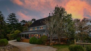 A two-story house with a porch, surrounded by trees and a gravel driveway. - Jewel of the Woods - Magnificent Views from an Incredible Lodge! (Clayton)