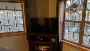 A cozy living room with a fireplace, a flat-screen TV, and comfortable seating.
