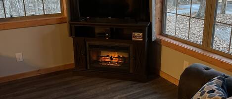 A cozy living room with a fireplace, a flat-screen TV, and comfortable seating.