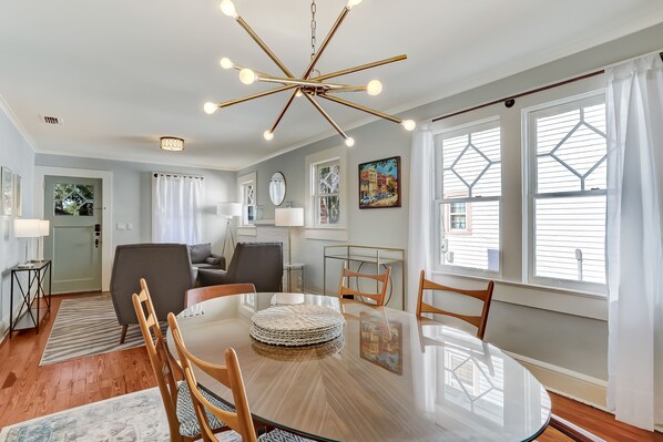 Enjoy meals in this stylish dining area with a round table, comfortable chairs, and a beautiful chandelier.