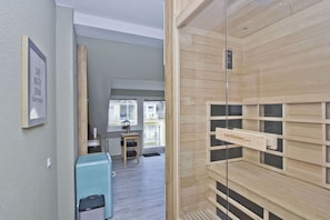 A modern apartment with a wooden interior, a small kitchenette, and a view of the outside. - Just 100 m from the beach, apartment with a balcony and private sauna - Apt. Eldena Vacation Rental 09 - (Middelhagen)