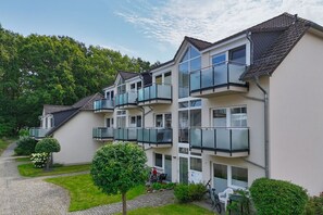 A multi-story residential building with balconies, a paved driveway, and surrounding greenery. - Just 100 m from the beach, apartment with a balcony and private sauna - Apt. Eldena Vacation Rental 09 - (Middelhagen)