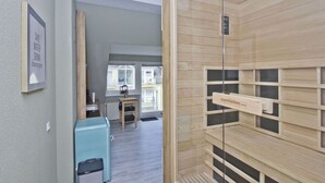 Eine moderne Wohnung mit Holzvertäfelung, einer kleinen Küchenzeile und Blick ins Freie.