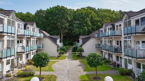 A row of modern apartment buildings with balconies, a central pathway, and well-maintained greenery. - Only 100 m to the beach, apartment with balcony and terrace - App. Eldena apartment 19 - (Middelhagen)