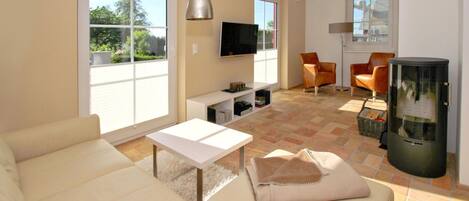 A modern living room with a sofa, a coffee table, a TV, and a fireplace.