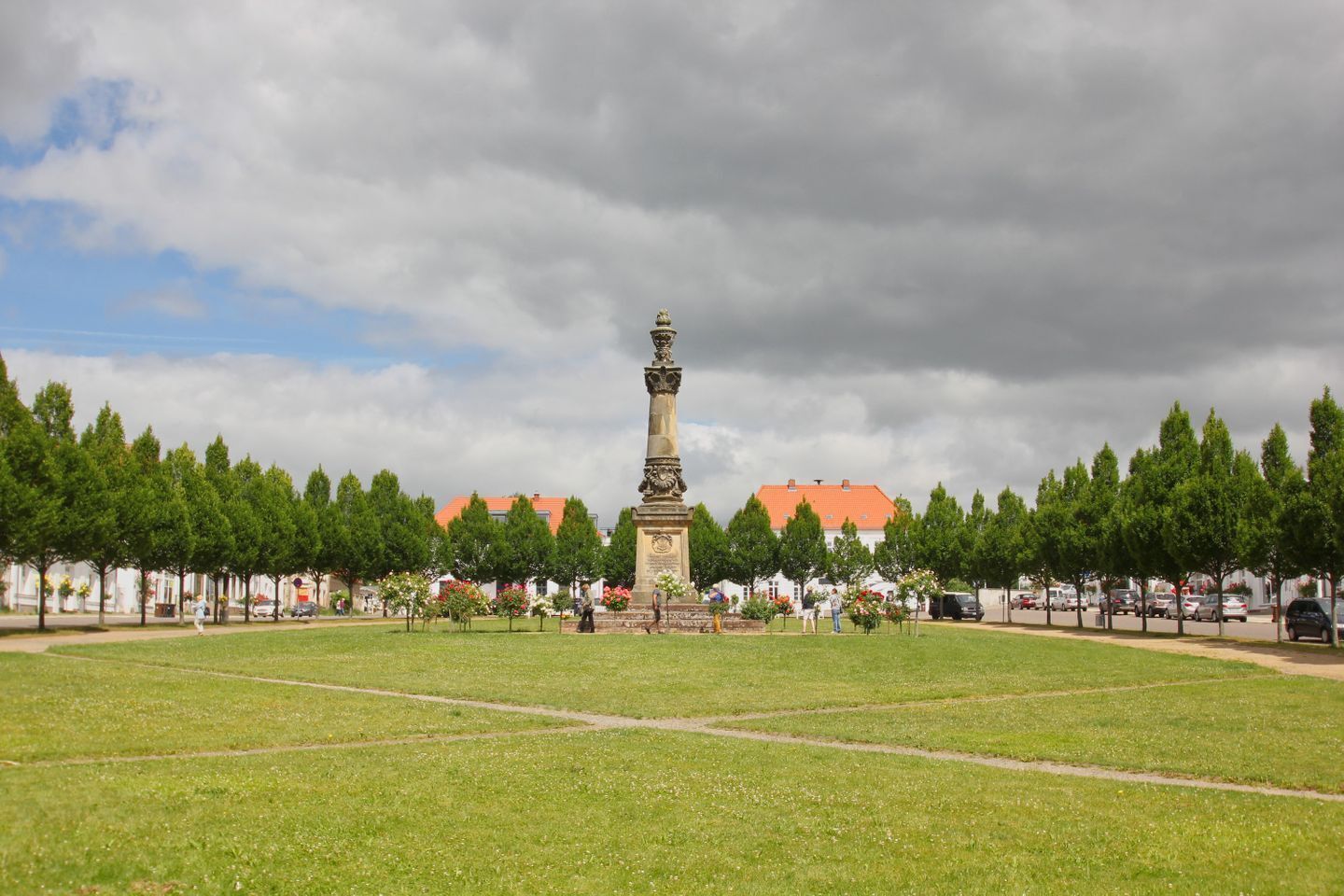 Ein Denkmal in einem Park mit blauem Himmel und Bäumen.