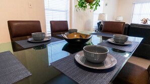 Een eettafel met vier kommen en borden, omringd door stoelen.