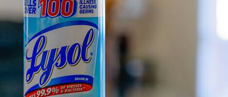 A Lysol disinfectant spray bottle with a label indicating it kills 99.9% of viruses and bacteria.
