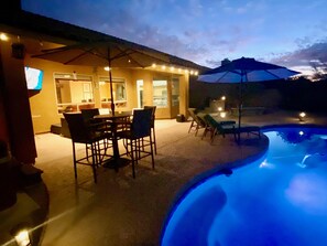 An outdoor patio area with a pool, dining table, chairs, and umbrellas. - Serene Desert Oasis in desirable Tatum Ranch of Cave Creek/Scottsdale (Cave Creek)
