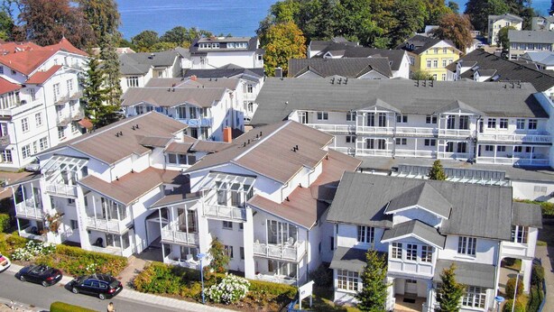 Un quartier résidentiel situé sur la côte, avec des immeubles à plusieurs étages dotés de balcons et offrant une vue sur la mer.