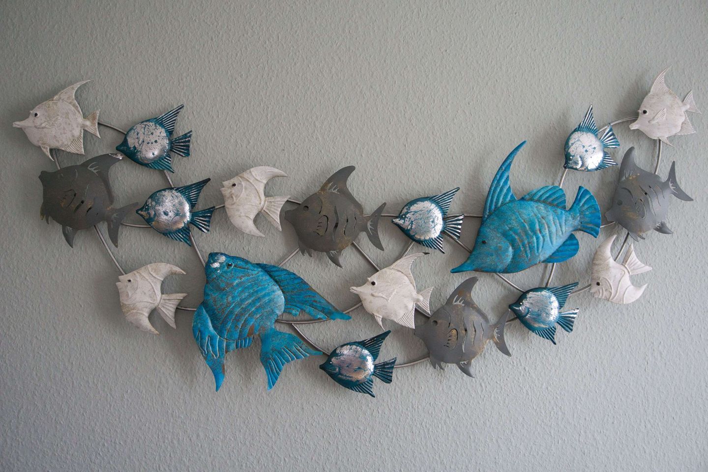 Una pared con un arreglo decorativo de peces.