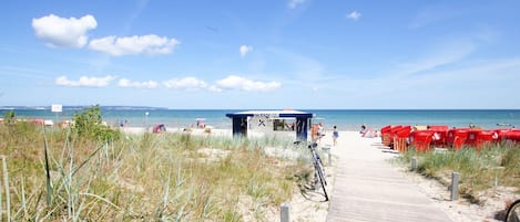 Une plage avec une promenade en bois qui mène à un bar de plage.