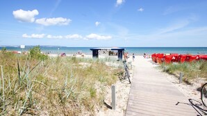 Une plage avec une promenade en bois qui mène à un bar de plage.