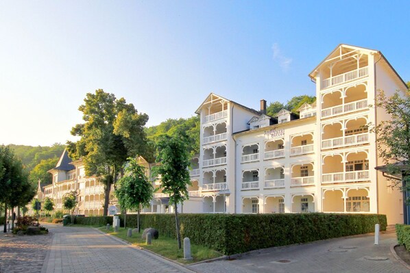 Ein mehrstöckiges Hotel mit Balkonen und einem Gartenweg.