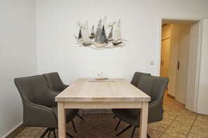 A dining area with a wooden table and four chairs.