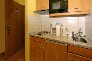 A compact kitchen with a microwave, coffee maker, kettle, and a sink. - Quiet location, beach-style vacation apartment with a veranda - Villa Möwe FeWo 06 - Villa (Göhren)