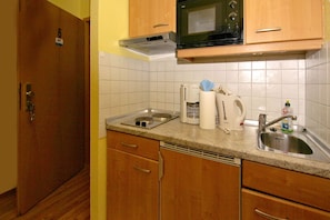 A compact kitchen with a microwave, coffee maker, kettle, and a sink. - Quiet location, vacation apartment in seaside style with veranda - Villa Möwe FeWo 06 - Villa (Göhren)