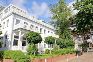 Ein weißes Gebäude mit Balkon und Garten.