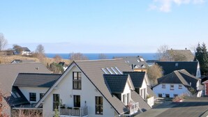 Un quartier résidentiel où les maisons se distinguent par leurs toits inclinés et leurs nombreuses fenêtres, et d’où l’on peut admirer une étendue d’eau.