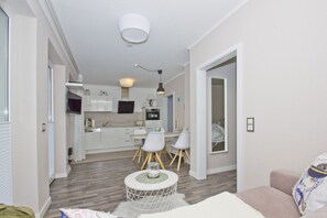 Um apartamento moderno com cozinha, sala de jantar e sala de estar.