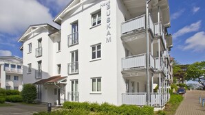 Un hotel de varios pisos llamado Haus BUSKAM con balcones y un cielo despejado.