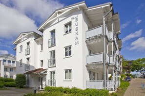 Ein mehrstöckiges Hotel namens Haus BUSKAM mit Balkonen und blauem Himmel.