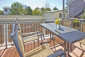 A balcony with wicker furniture and a metal table, featuring a vase with yellow flowers. - Central but quiet, balcony, free swimming pool and sauna - Villa Elisenhof apartment 2 (Göhren)