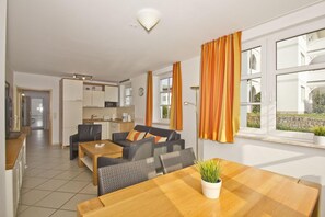 Un appartement moderne comprenant un coin repas, une cuisine et un salon.