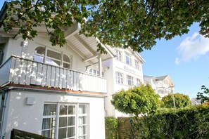 Un immeuble de deux étages doté d’un balcon et de grandes fenêtres.